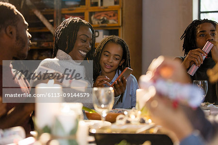 Mother and daughter using smart phone at Christmas dinner