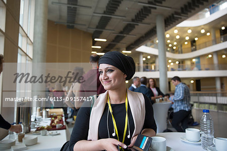 Smiling, confident businesswoman in headscarf at conference