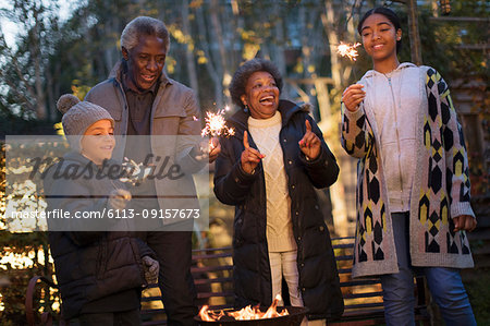 Grandparents and grandchildren playing with firework sparklers