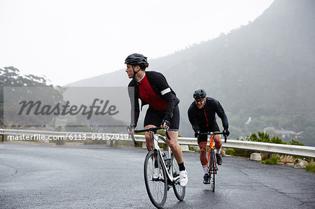 Dedicated male cyclists cycling on wet road