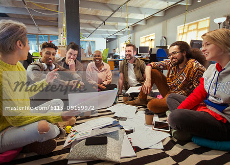 Creative business team meeting, brainstorming in circle on floor