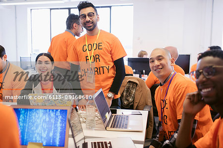 Portrait confident hackers coding for charity at hackathon