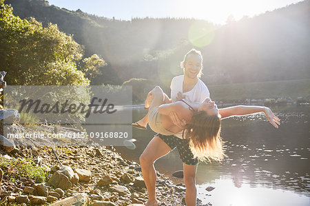 Playful couple at sunny summer lake
