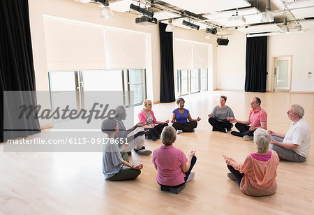 Serene active seniors meditating in circle