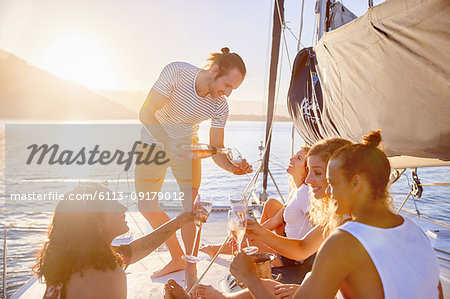 Friends drinking champagne on sunny catamaran