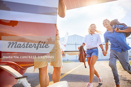 Happy, eager couple boarding small airplane