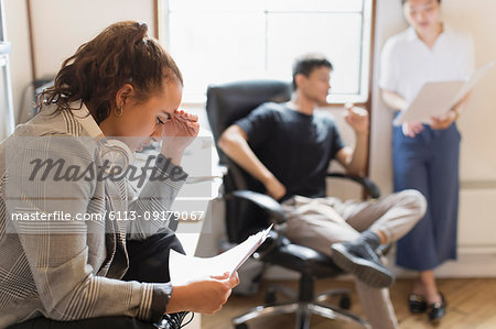 Focused creative businesswoman reading paperwork