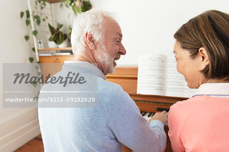 Active senior couple playing piano