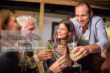 Friends toasting cocktails on patio