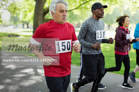 Active senior man running sports race in park