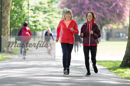 Active senior women friends jogging in park