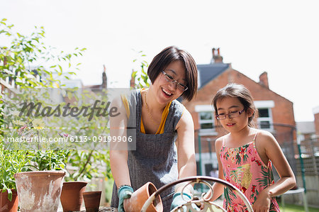 Mother and daughter gardening in sunny yard