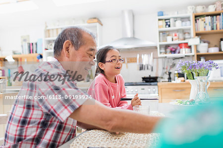 Grandfather and granddaughter at kitchen table