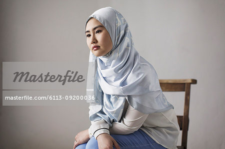 Thoughtful young woman in blue silk hijab