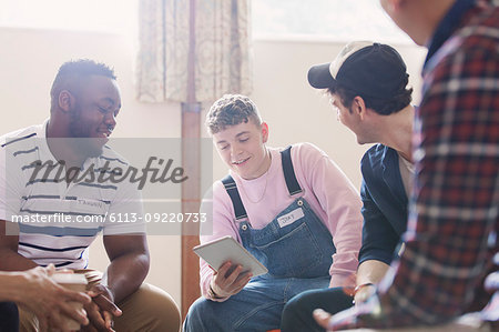 Men with digital tablet talking in group therapy