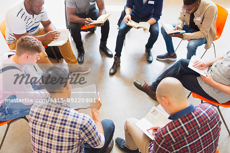 Men reading and discussing bible in prayer group