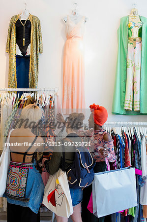 Young women friends shopping in clothing store