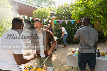 Male friends enjoying backyard summer barbecue