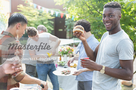 Portrait smiling young man enjoying barbecue with friends