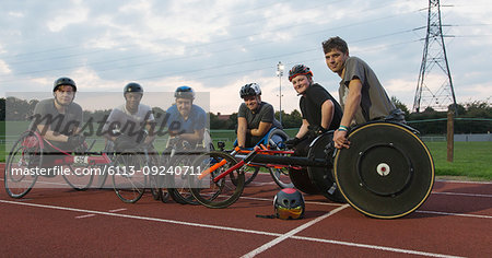 Portrait confident paraplegic athletes training for wheelchair race on sports track