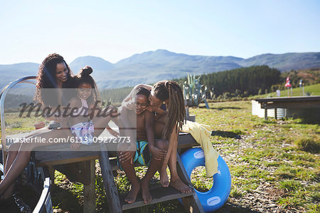 Happy lesbian couple and kids at sunny, summer poolside