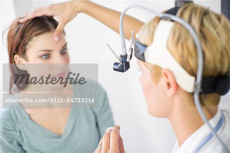 ENT physician Examines the Throat of a Female Patient