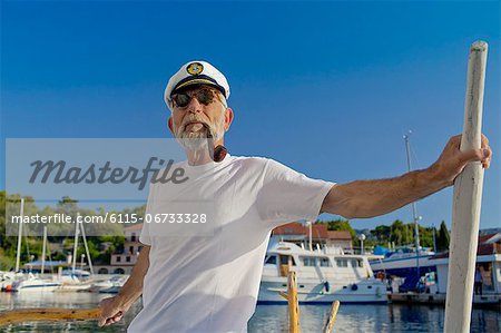 Croatia, Senior man with captain's hat on sailboat