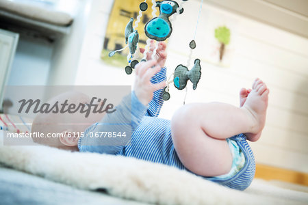 Baby boy playing with mobile toy, Munich, Bavaria, Germany