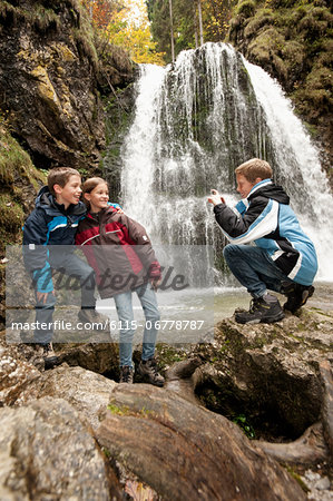 Three Children In Front Of A Waterfall, Bavaria, Germany, Europe