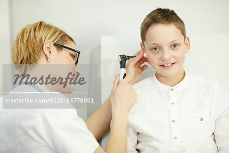 Female doctor examining boys ear, Osijek, Croatia