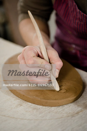 Craftswoman carving pattern into clay, Bavaria, Germany, Europe