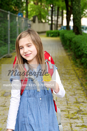 Little girl walking home from school, holding a flower, Munich, Bavaria, Germany