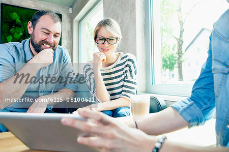 Young people in a cafe using digital tablet