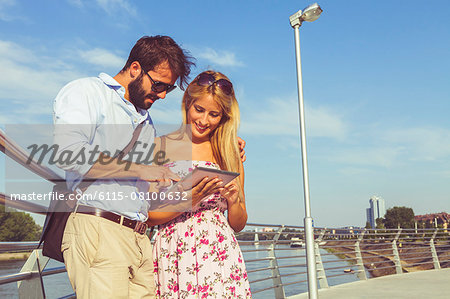 Young couple using digital tablet outdoors