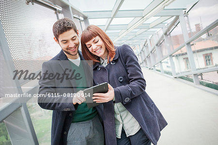 Young couple in airport building using digital tablet