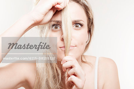 Young woman holding strand of hair