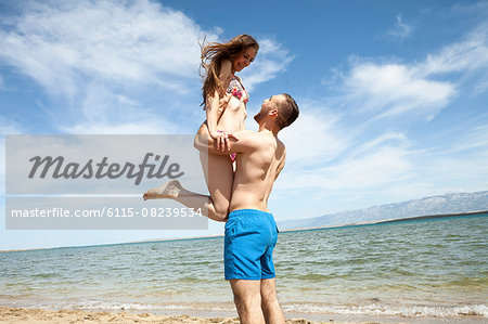 Happy young couple on beach fooling around