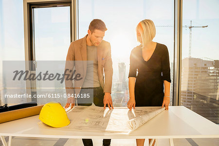 Architects in office examining blueprint
