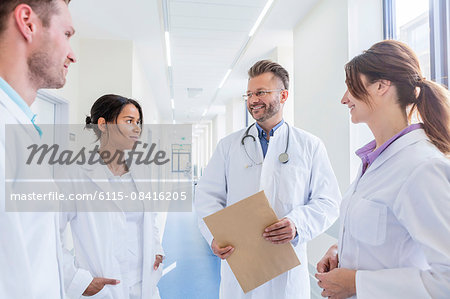 Doctor and coworkers talking in hospital corridor