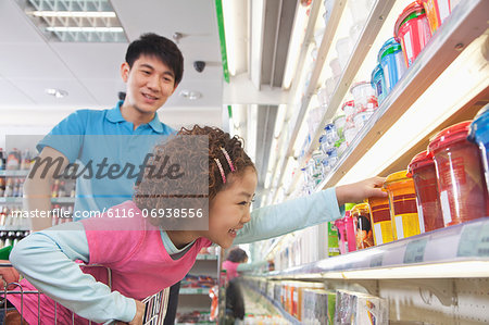 Little Girl Reaching for Food in Supermarket