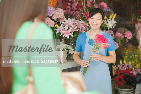 Florist Giving Bunch Of Flowers To Customer