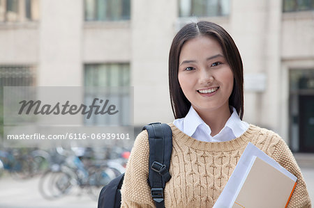 Young student holding books, portrait