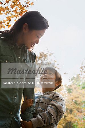 Mother and son walking in the park, holding hands