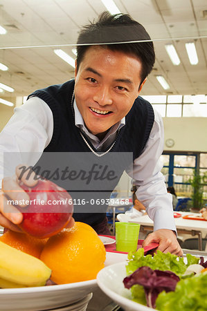 Teacher reaching for healthy food in school cafeteria