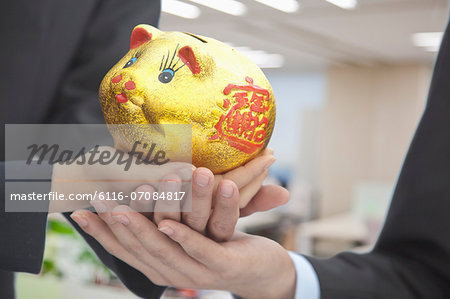 Holding Chinese Gold Piggy Bank