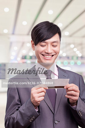 Young businessman looking at airplane ticket, Beijing