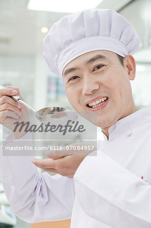Chef with spoon, tasting food, portrait