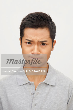 Portrait of angry and frustrated young man, studio shot