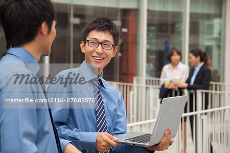 Businessmen working outside with laptop