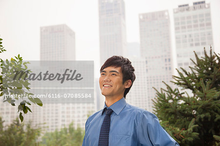 Young businessman smiling in the park, portrait